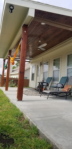 A covered patio with lawn chairs and a table