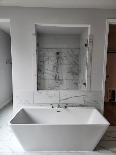 A large white bath tub sitting inside of a bathroom