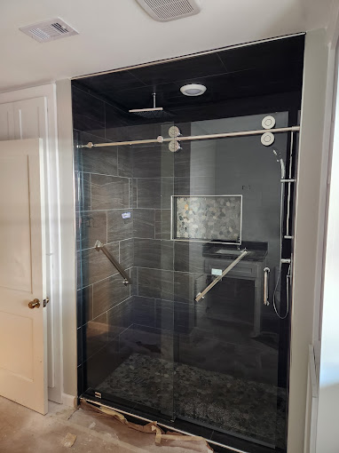 A bathroom with a walk in shower next to a door