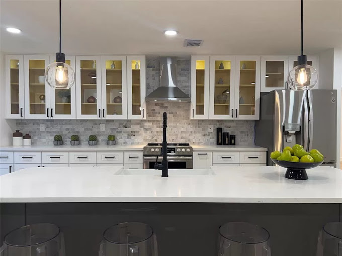 A kitchen with a center island and a bowl of fruit on the counter